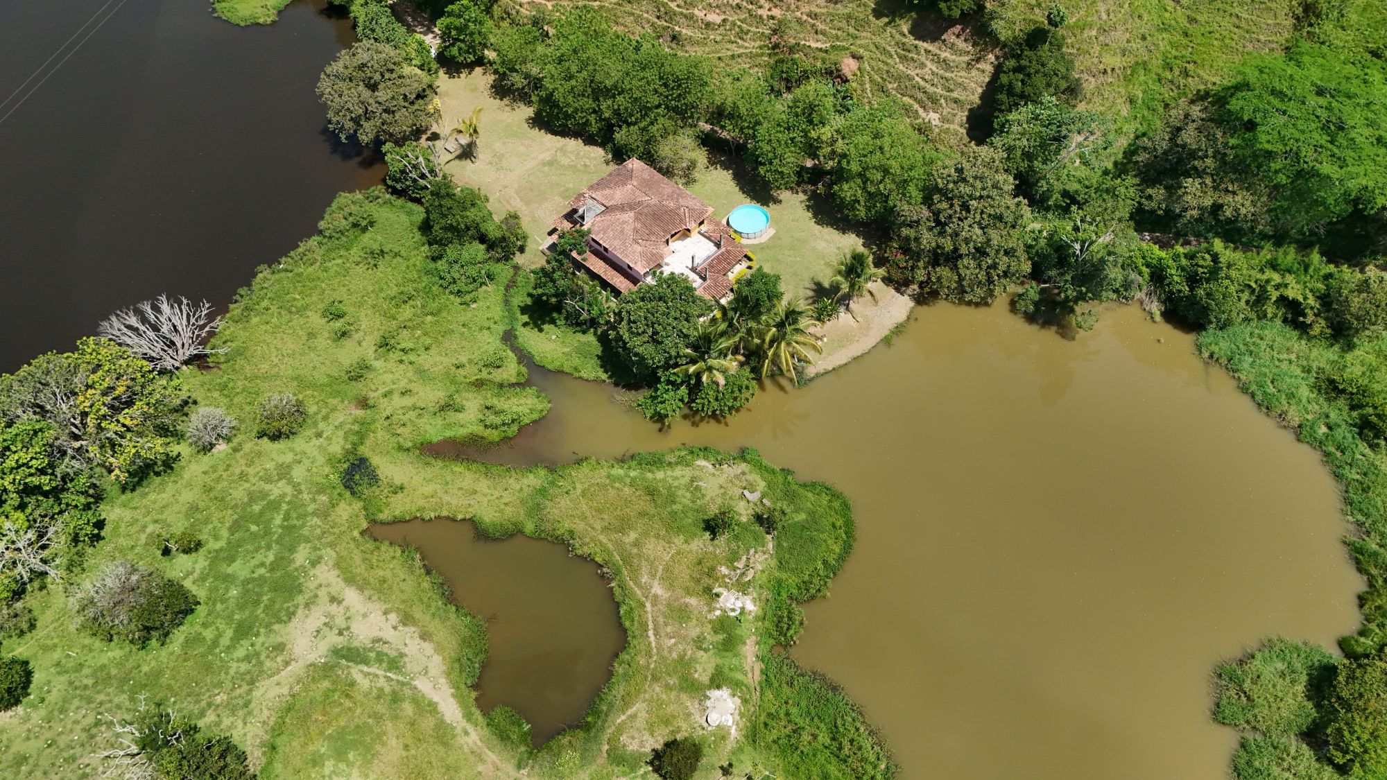 Vista aérea de los lagos privados de La Frisolera, mostrando la casa principal rodeada de zonas verdes y el agua donde realizamos la jornada de pesca.